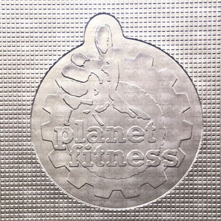 Planet Fitness logo embossed on a textured metallic surface