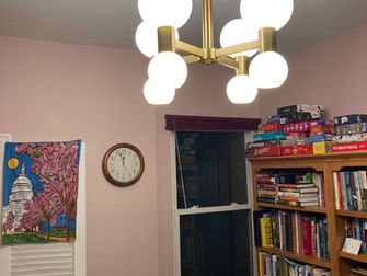A light fixture with bright white globes hangs from the ceiling of a room.