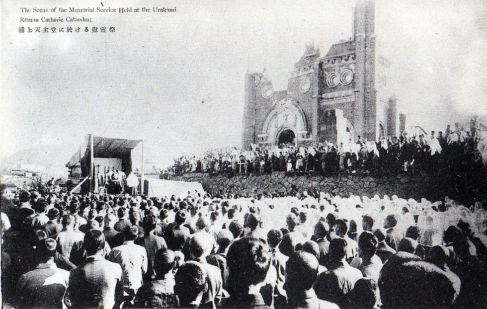 A photo of a crowd of people in front of the facade of a mostly-destroyed cathedral.