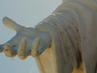 A hand is outstretched, palm up, as though offering help.