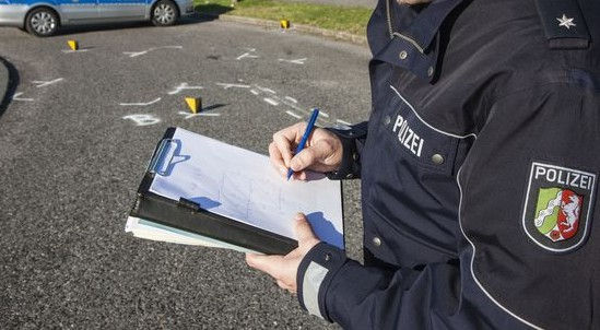 Polizist nimm einen Unfall am Unfallort auf und erstellt eine Unfallskizze