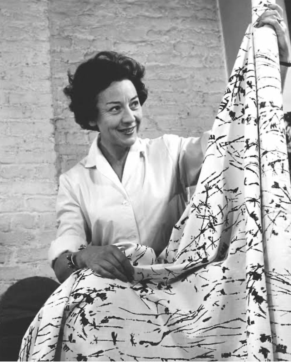 Lucienne Day holding
up her fabric