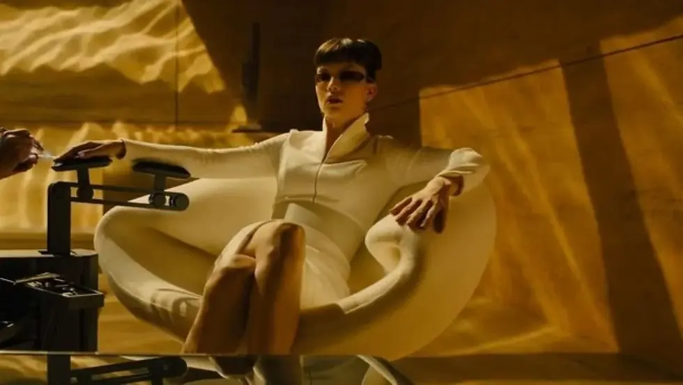 A woman sitting in a yellow bright room.