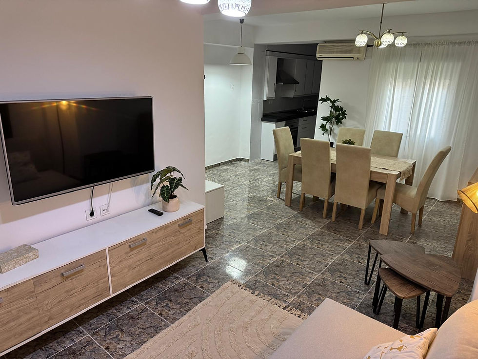 Sala de estar y comedor modernos con TV y mesa.