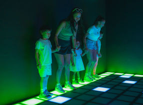 group standing on safe LED floor tiles illuminated in green showing team collaboration at LAVALED 'Floor is Lava' challenge in Chaweng, Koh Samui