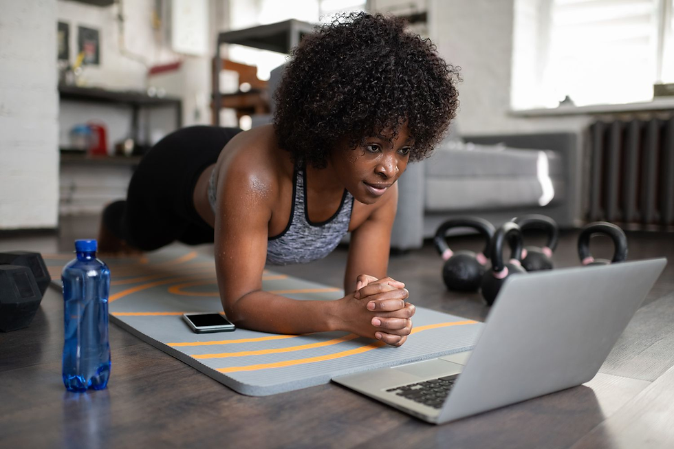 Woman working out from home with a Wellstra online coach on her laptop