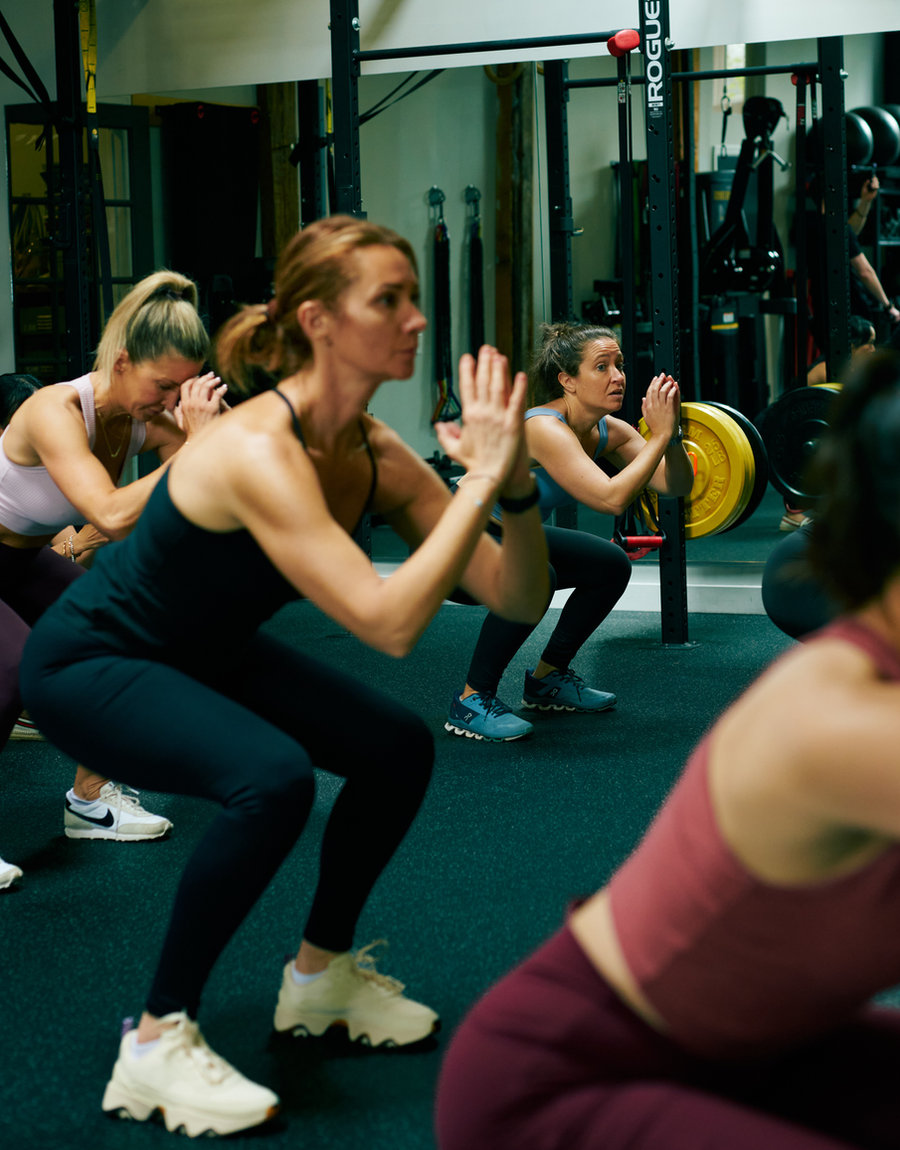 A coached barbell squat with focus on form at The Compound