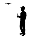 Silhouette of man wearing cap holding a drone controller flying a drone