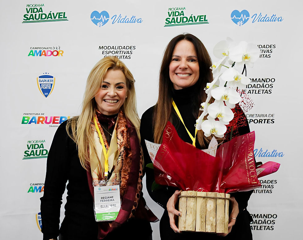 A secretária adjunta de Esportes de Barueri, Regiane Ferreira, entrega um buquê de orquídeas à secretária estadual de Esportes, Cláudia Carletto © Prefeitura de Barueri