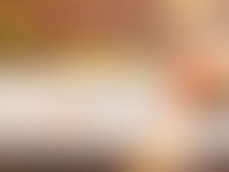 Woman relaxes in a hot tub outdoors, head back and eyes closed. Sunlight filters through trees, creating a serene, warm ambiance.