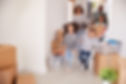 smiling-family-carrying-boxes-into-new-h