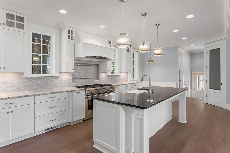 Beautiful kitchen in new luxury home with large island, hardwood floor, and pendant lights