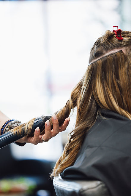 stylist Deanna curling clients hair