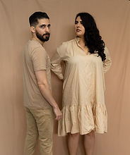 Un hombre y una mujer posando en ropa color beige