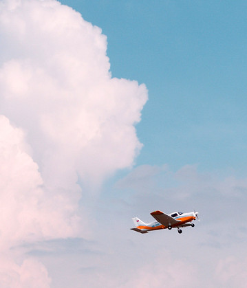 A plane flying in the sky with clouds 
