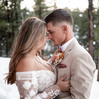 Couple share intimate moment in front of a forest after their wedding