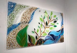 Fused glass wall art installation at Mayo hospital featuring layered glass forms, representing a calming nature scene for healing.