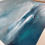 Thumbnail: An atmospheric seascape with a grey sky. The navy sea has green turquoise colour pops left side detail