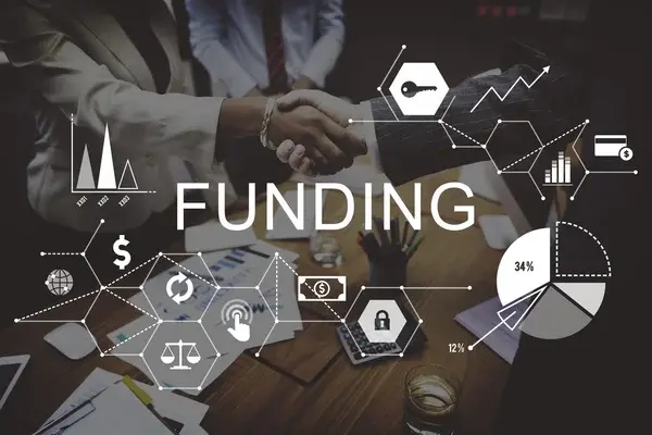 Business professionals sealing a funding customized deal for their MSME with a handshake, surrounded by financial charts and data graphics, symbolizing growth and investment opportunities.