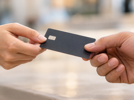 Two hands exchanging a credit card for payment.