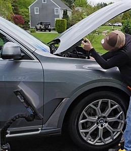 Dent Repair Technician working on a BMW SUV Fender