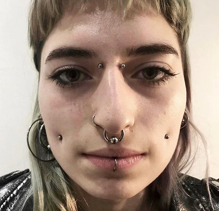 Image d'une personne avec des piercings visage chez American Body Art, mettant en valeur notre expertise en modification corporelle et expression de soi.