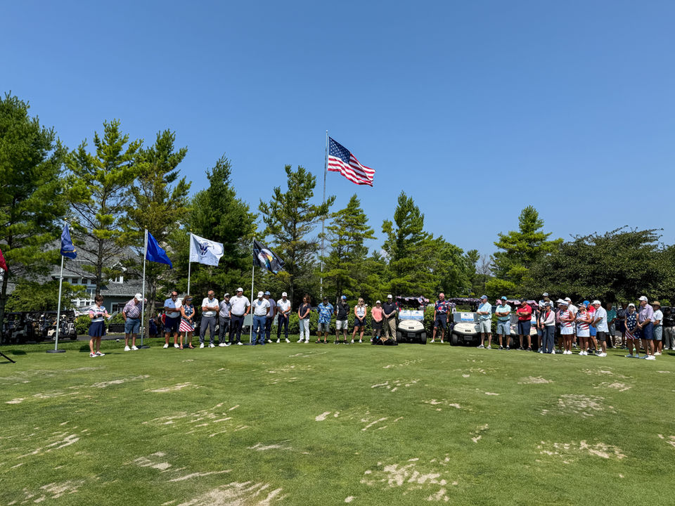 The president addressing the crowd with committee members and sponsors in the background