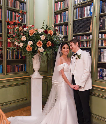 Bride and Groom adjacent to large floral arrangement at Meridian House, Washington DC. 