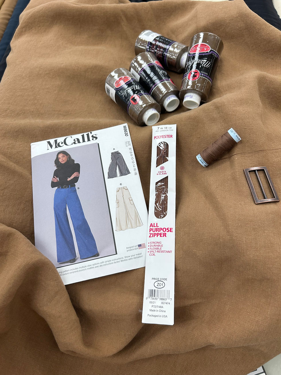 sewing pattern zipper, thread, buckle and linen fabric