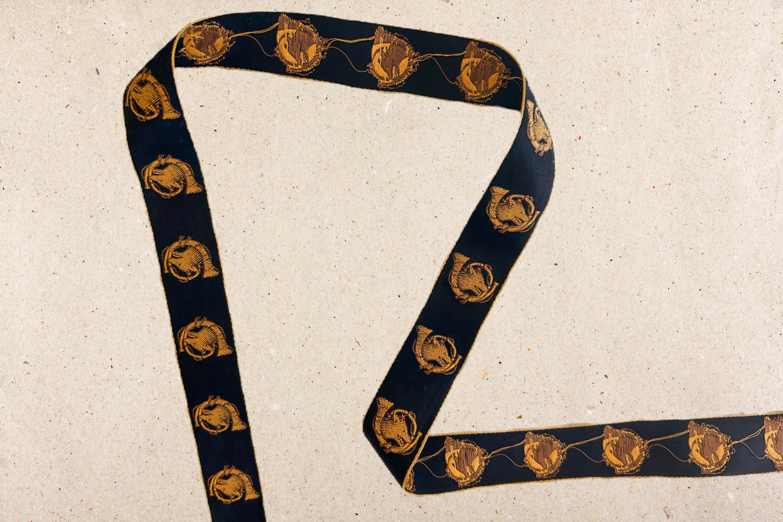 navy ribbon trim in cotton with gold edges and fox and horn embroidered on a beige background