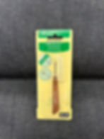 Brown handled seam ripper by clover in yellow packing on denim fabric