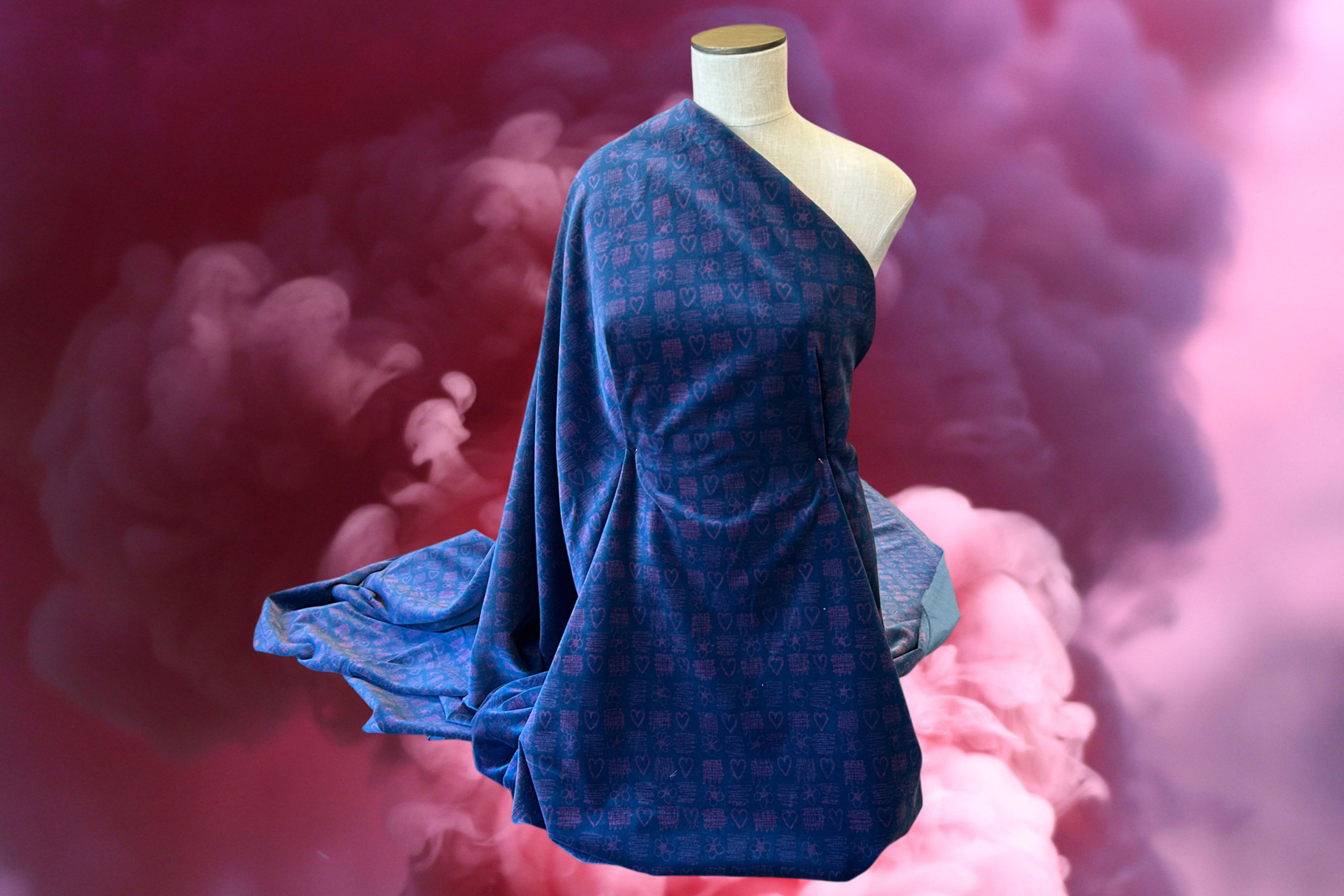 blue and pink floral heart velvet fabric draped over a mannequin with a cloudy pink sky