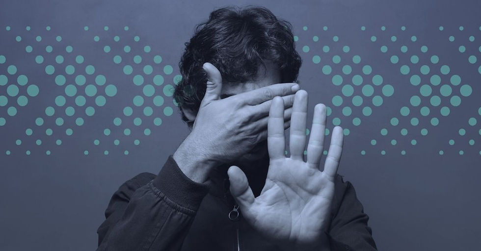 A person hiding their face with one hand and holding up another hand.