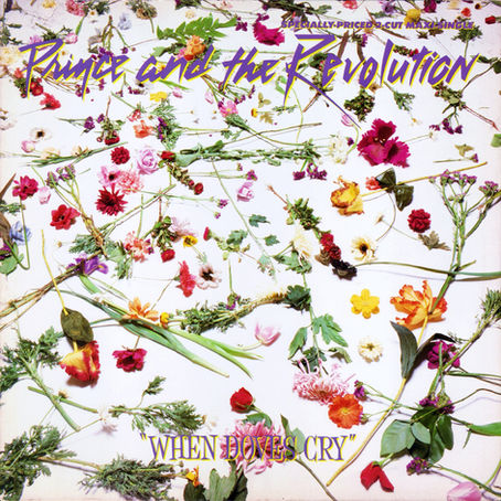 White floral‑themed single artwork featuring stylised purple script for “Prince and the Revolution” and bold title text for “When Doves Cry.”