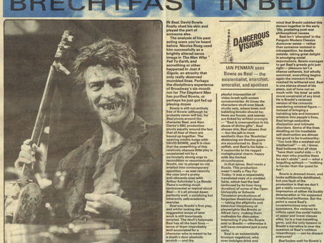 A newspaper page featuring David Bowie in ragged clothing, holding a banjo, with wild hair and a grimy face. The headline reads “Brechtfast in Bed,” and the article analyses Bowie’s performance in the BBC production of Baal.