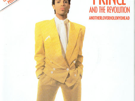 Cover art featuring Prince in a bright yellow suit with typography for “Anotherloverholenyohead” and “I Wanna Be Your Lover.”