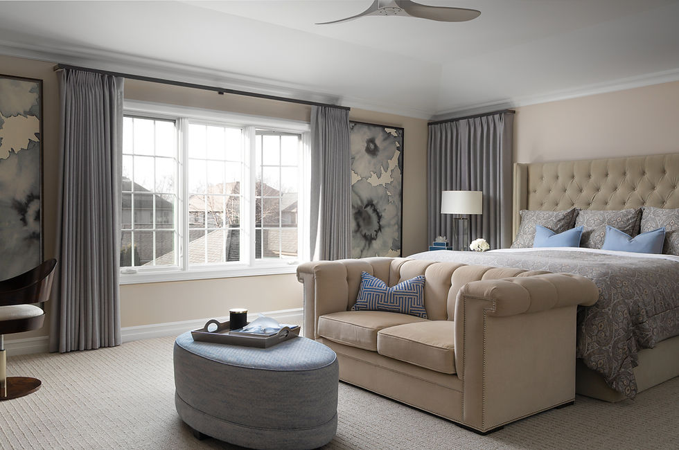 Modern primary suite with tufted bed and sitting area