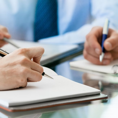 Hands writing in notebooks
