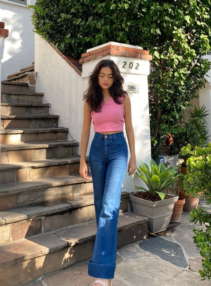 Woman in pink top and jeans descends steps