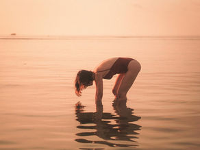 Figura feminina interagindo com superfície espelhada em cena abstrata, representando autoconhecimento, dualidade do eu e reflexão existencial