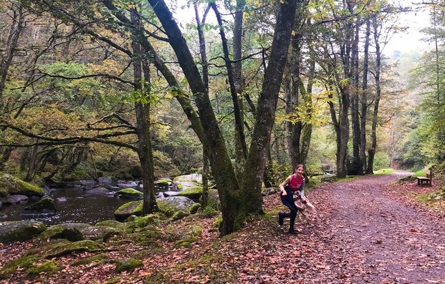 Child in autumnal forest with river