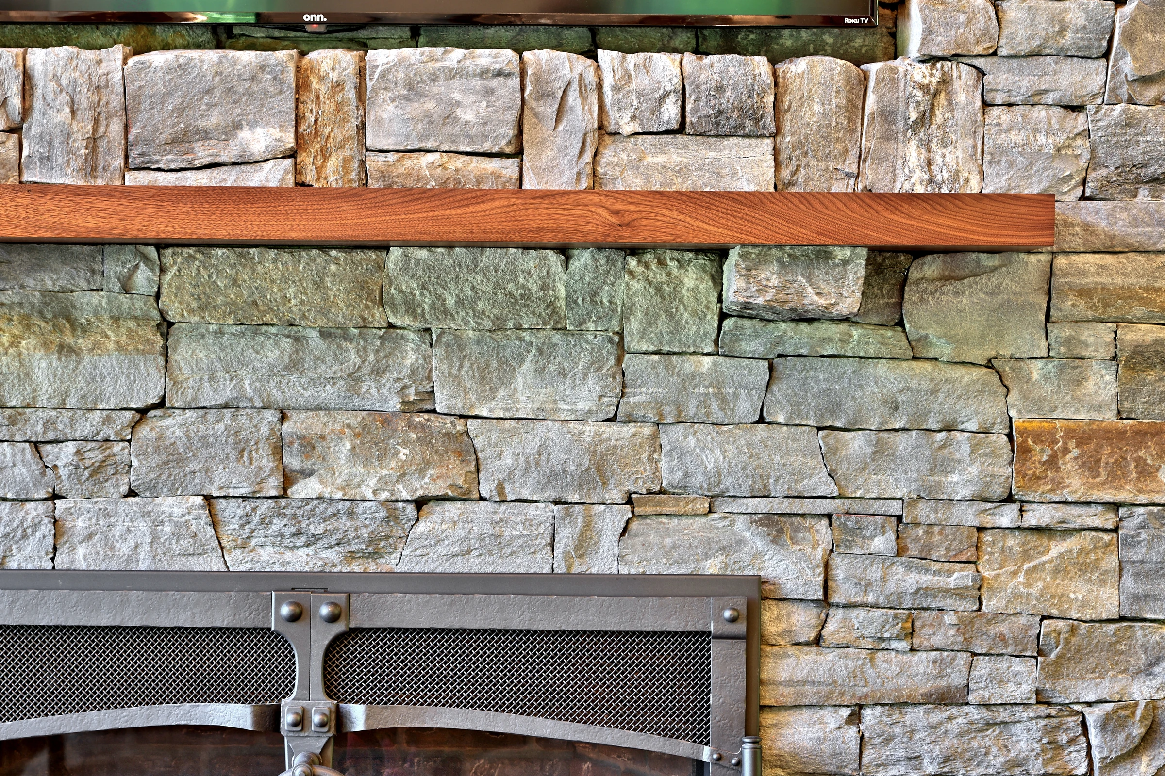 Varied stone textures and a wood mantel at the Killington home fireplace.