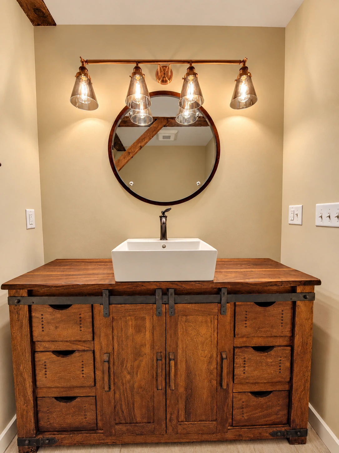 Rustic wood vanity with a rectangular vessel sink, round mirror and warm lighting.