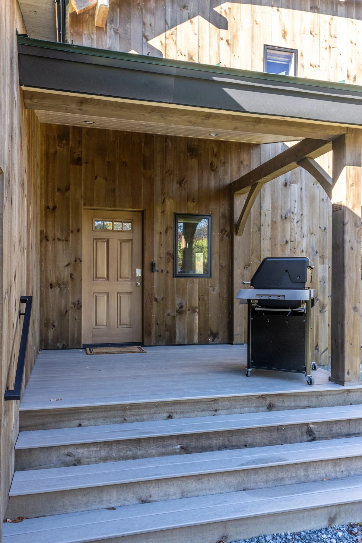 Timber posts shelter the stepped entry of a Hudson Design and Build custom home in Rochester, Vermont.