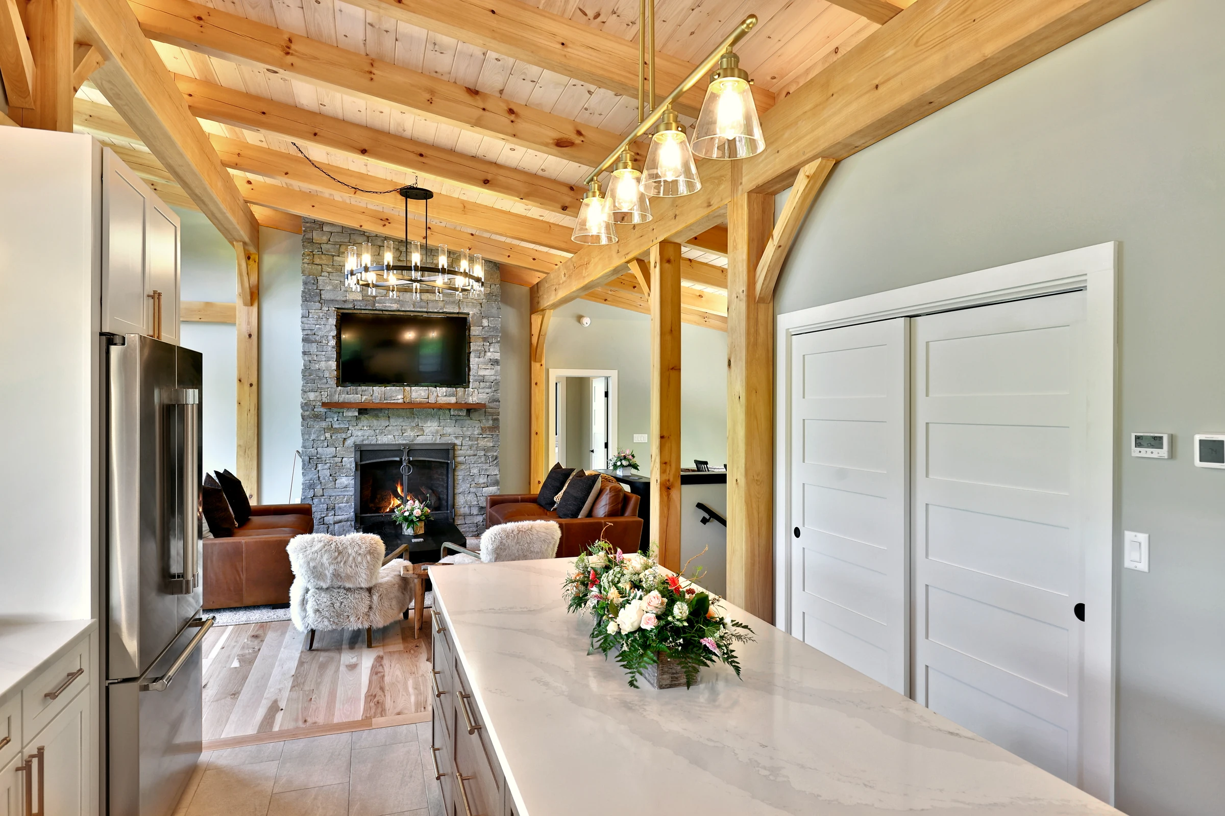 Pendant lights above the kitchen island beneath exposed timbers in the Killington home.