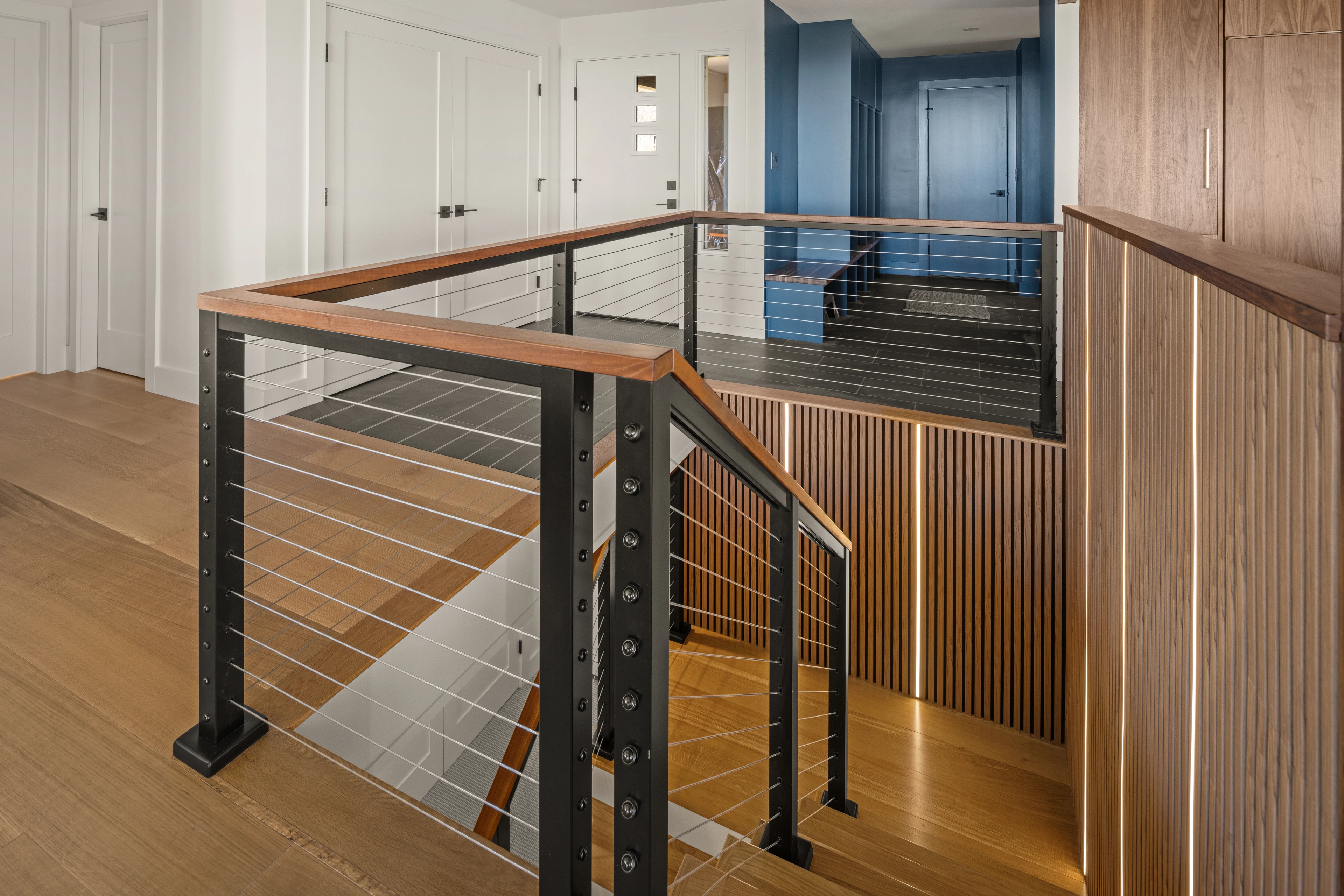 Wood stair handrail, dark posts and horizontal cable railing in Quechee.