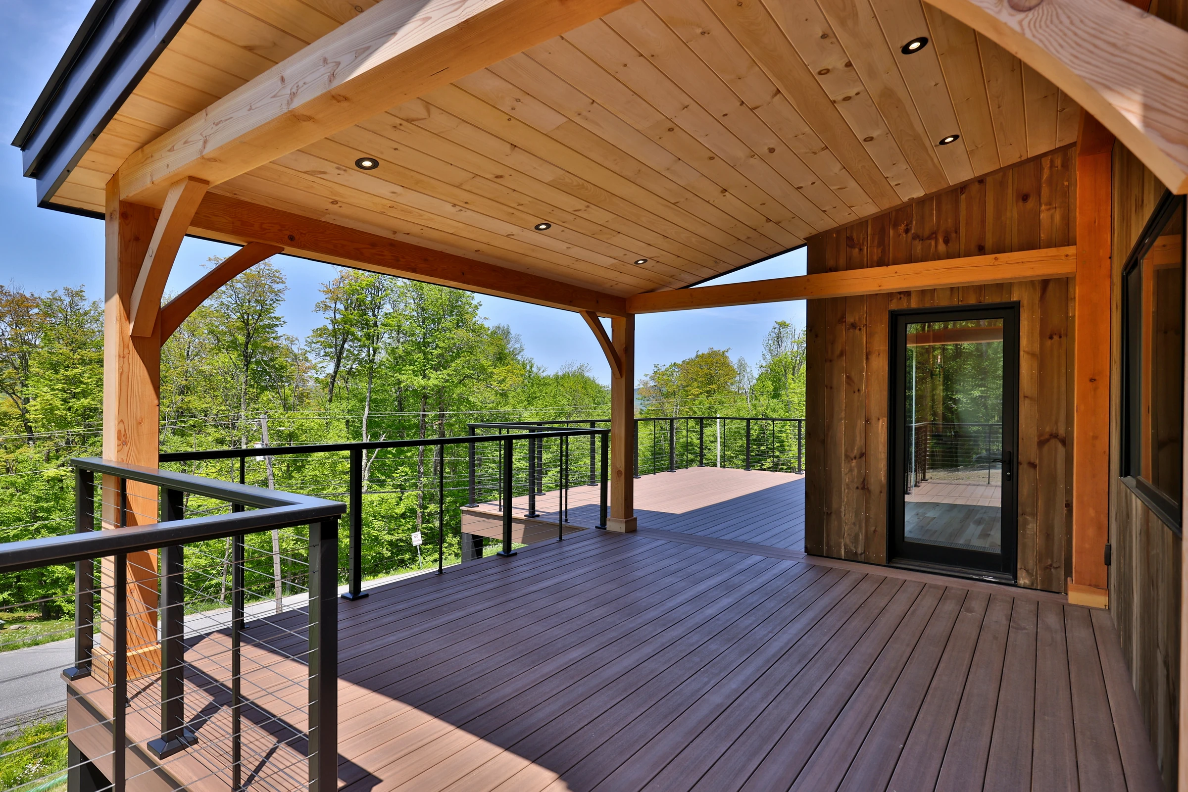 Timber posts and braces supporting a wood-lined covered deck at the Killington home.