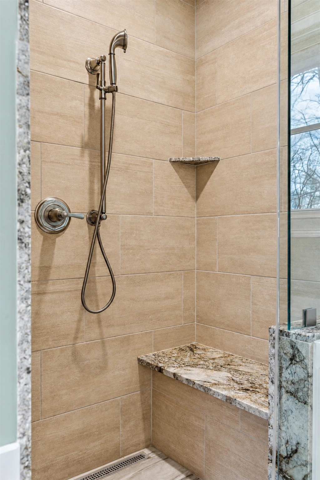 Stone shower walls with a built-in bench and handheld shower fitting.