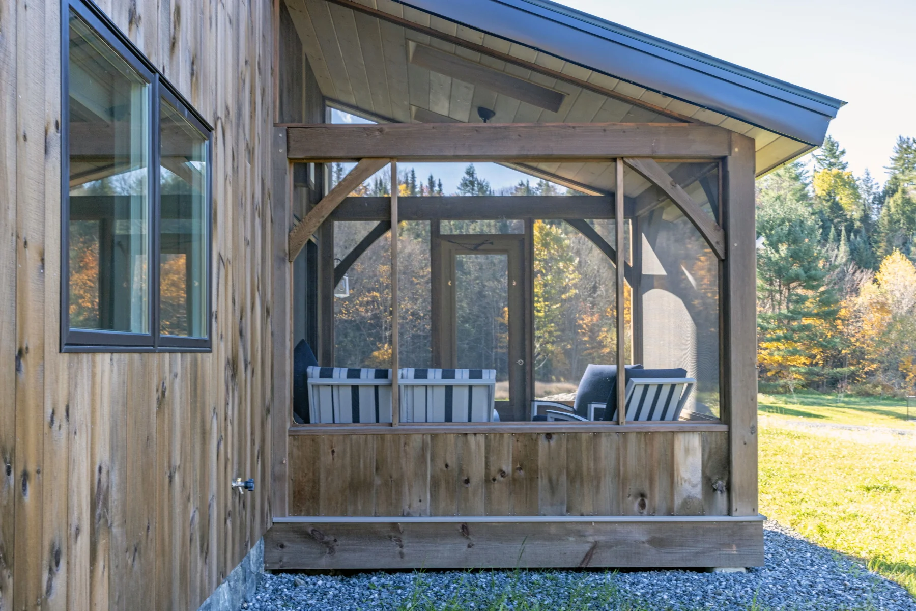 Screened porch framed with exposed timbers on a Hudson Design and Build custom home in Rochester, Vermont.