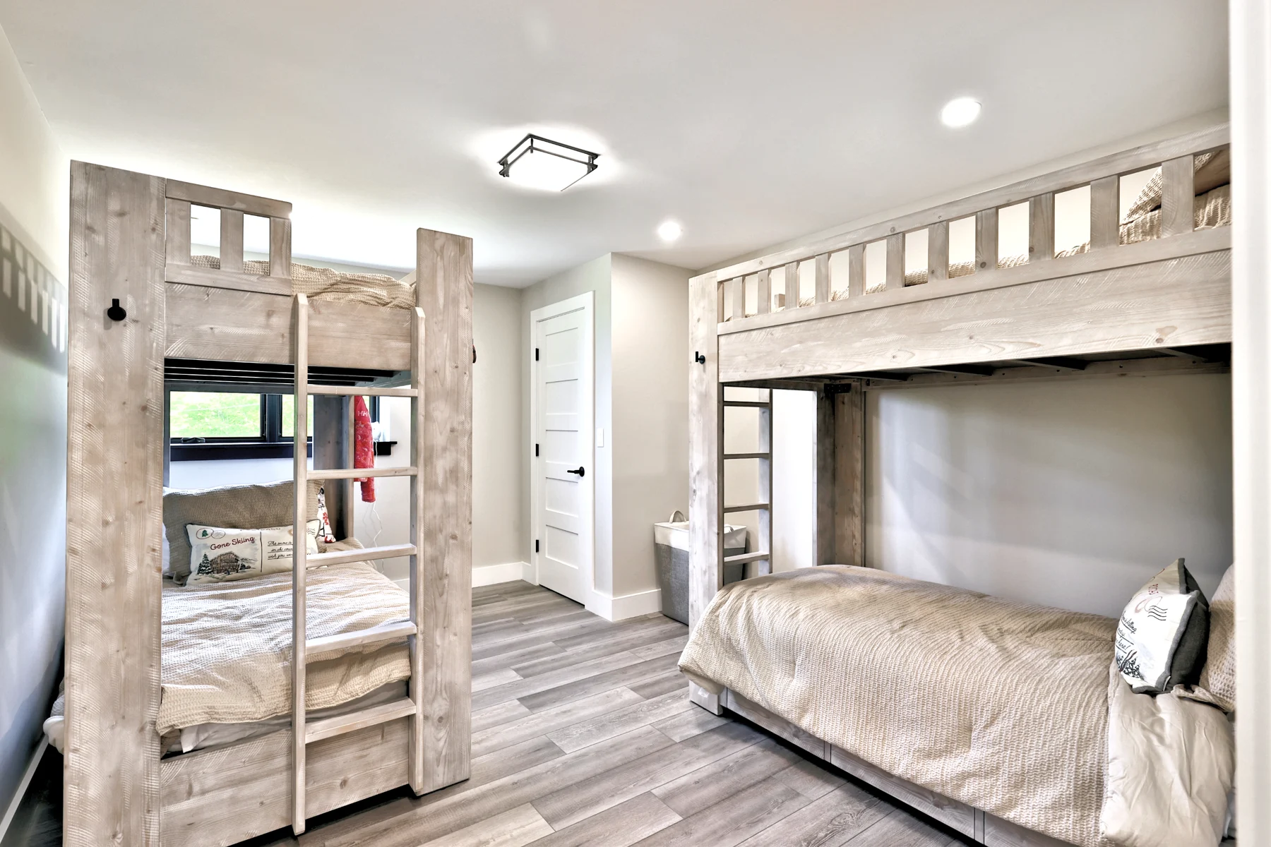 Built-in wood bunk beds provide guest sleeping space in a Hudson Design and Build mountain home in Killington, Vermont.